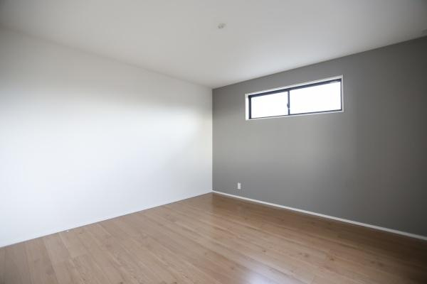 横尾東町2丁目2期3号棟の洋室|落ち着いた色合いの壁が印象的な洋室です。窓からの自然光が入り室内全体が明るく感じられます。床はフローリング仕上げでお手入れもしやすい仕様です。空間に余裕がありさまざまなレイアウトが可能です。