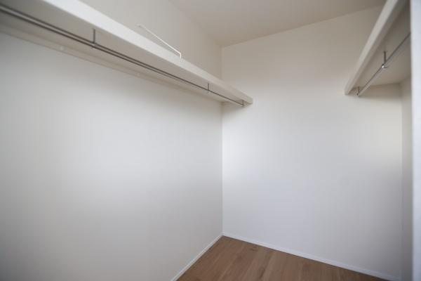 横尾東町2丁目2期3号棟の収納|壁一面にハンガーパイプが設置されており衣類をすっきり収納できます。広々とした収納スペースが確保されています。床まで無駄なく使える設計で整理しやすい環境です。シンプルな内装で使い方の幅が広がります。
