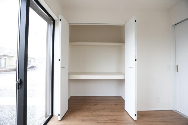 横尾東町2丁目2期3号棟の収納|白を基調とした収納スペースが室内をすっきりとした印象にします。棚付きで整理整頓がしやすい設計です。両開きの扉で使い勝手が良い収納です。窓からの光が収納内部にも届く位置に配置されています。