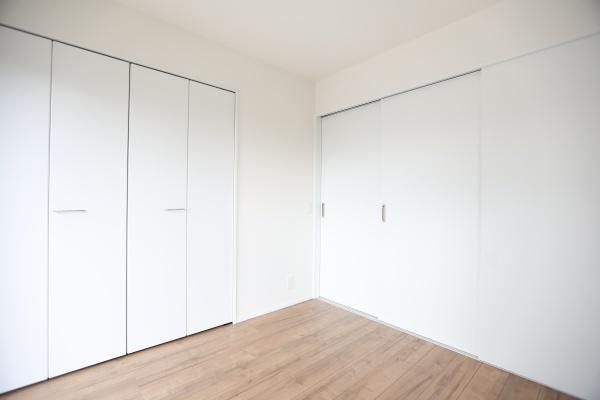 横尾東町2丁目2期3号棟の洋室|白を基調とした室内が清潔感を演出しています。広々と使える洋室で収納スペースも充実しています。床材のナチュラルな色合いが落ち着いた雰囲気を醸し出します。シンプルで使いやすい洋室です。