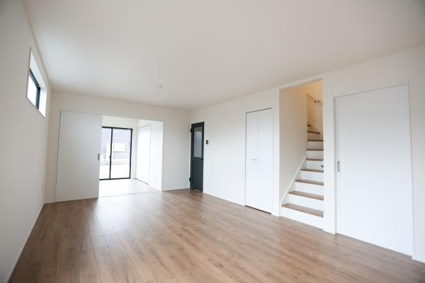 横尾東町2丁目2期3号棟の居間・リビング|リビングには明るい光が差し込み室内が爽やかな印象です。木目調のフローリングがあたたかみを感じさせます。階段や収納扉も配置されており使いやすい空間となっています。