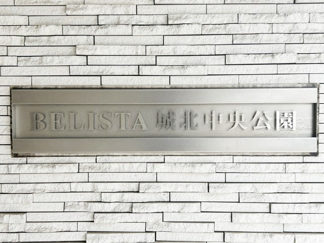 【現況写真】 | BELISTA城北中央公園 | エントランスに掲げられた、マンション名を示す館銘板。さほど激しく主張はしませんが、しっかりと掲示されています。～即日のご見学可能～　お問合せはお気軽にどうぞ。