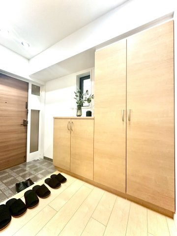 ピュアハイツ南万騎が原の玄関|木目調の下足入れと明るいフローリングが調和した玄関。窓から自然光が差し込み、爽やかな印象の空間です。