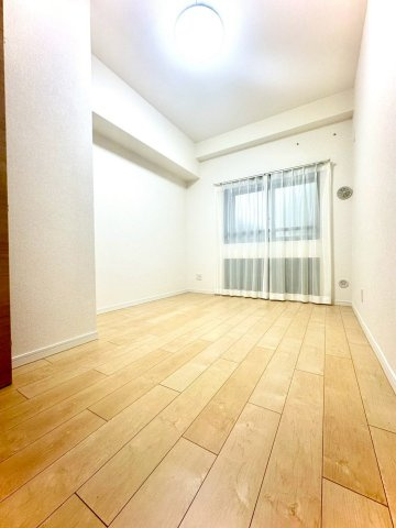 ピュアハイツ南万騎が原の洋室|ナチュラルな木目フロアが温もりを感じさせる洋室。採光窓から柔らかな光が入り、落ち着いたプライベート空間を演出します。