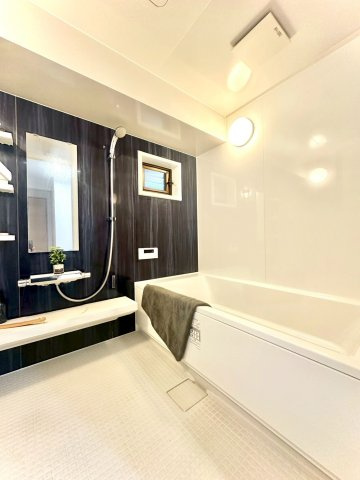 ピュアハイツ南万騎が原の浴室|1坪サイズの広々とした木目調パネルが高級感を演出するバスルーム。浴室乾燥機付きで、雨の日の衣類乾燥にも便利です。