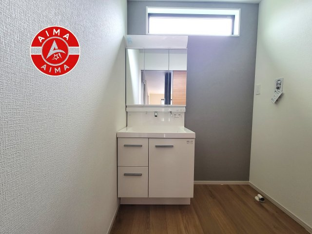 糸島市前原北2丁目第1-3棟（1号棟）の内観：施工例|毎日使うものだから清潔な空間を保ちたい水回り。洗面にはそんな願いを解消させてくれる収納アイデアが満載です。三面鏡の裏側にはキャビネットが現れ小物から背の高い物まで収納できます。