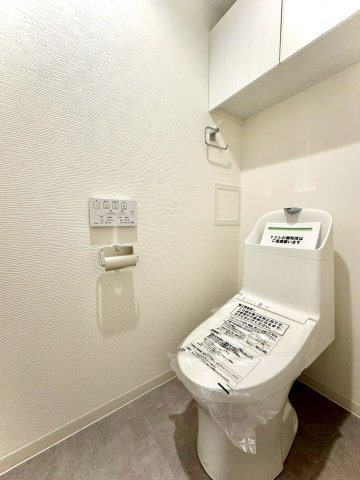 東急ドエルアルス大倉山東のトイレ|シンプルで清潔感あるトイレ空間。上部収納があり、日用品やストック類もすっきり整理できます。