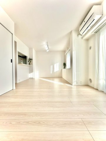 東急ドエルアルス大倉山東の居間・リビング|長く伸びる木目フローリングが奥行きを演出。日差しが床に落ちて、美しい陰影を生んでいます。