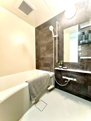 東急ドエルアルス大倉山東の浴室|落ち着いたダークブラウン調の壁面が高級感を演出。浴室乾燥機付きで、雨の日も安心して洗濯できる快適仕様です。