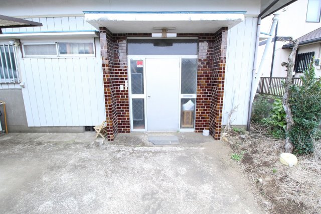 小山市羽川の玄関|どこか懐かしさを感じる、趣のある玄関まわり。個性的なタイル張りの柱がアクセントになっており、住まいの第一印象を引き締めています。庇付きで雨の日の出入りも安心です。