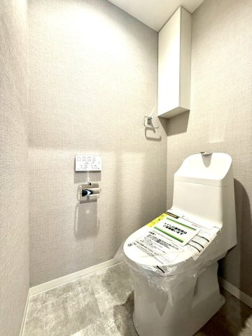 セザールたまプラーザのトイレ|落ち着いたトーンの壁紙がホテルライクな雰囲気を演出するトイレ空間。吊り戸棚付きでストック収納も充実しています。