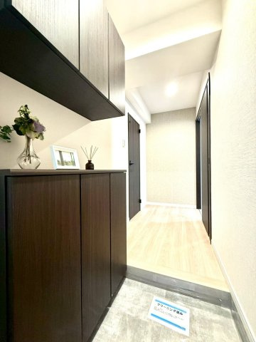 セザールたまプラーザの玄関|木目のシューズボックスと間接照明が温かみを感じさせる玄関空間。奥へ伸びる廊下が、住まいの広がりを感じさせます。