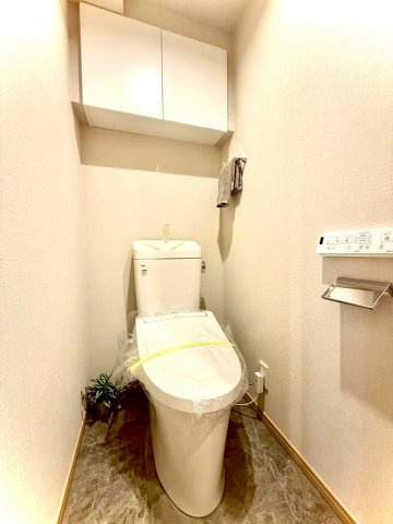 扶桑ハイツ南太田のトイレ|落ち着いたトーンでまとめた温水洗浄便座付きトイレ。
上部収納があり日用品もすっきりしまえ、清潔感に満ちた空間です。