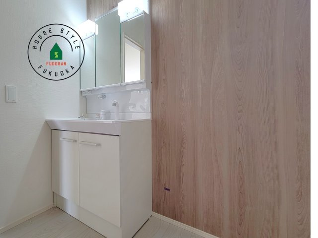 糸島市前原北2丁目第1-3棟（1号棟）の内観：施工例|毎日使うものだから清潔な空間を保ちたい水回り。洗面にはそんな願いを解消させてくれる収納アイデアが満載です。三面鏡の裏側にはキャビネットが現れ小物から背の高い物まで収納できます。