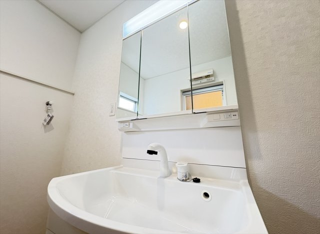 【独立洗面台】 | 朝霞市宮戸3丁目　新築一戸建住宅　全16棟　(志木本店) | 三面鏡洗面化粧台は収納部分を鏡が隠してくれますので、スキンケア用品を収納出来ます。
また多角的にチェックできるのでヘアアレンジやメイクもスムーズに行えます。
