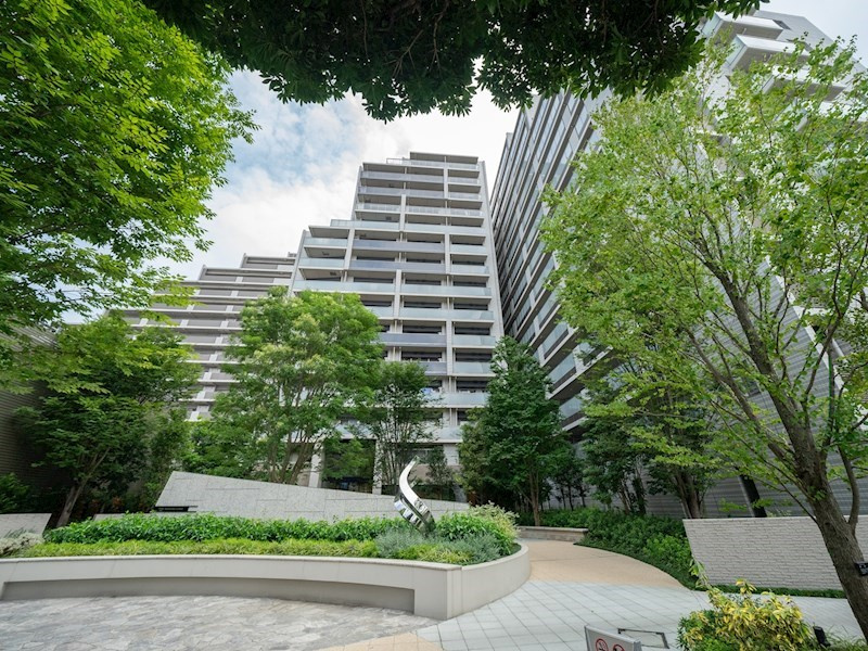 【Mansion exterior】白系モノトーンの外壁に基壇部を包み込む緑が清涼感を感じさせます。