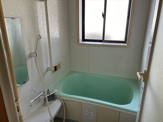 薪ストーブのある店舗付き住宅の浴室|シンプルなユニットバス
