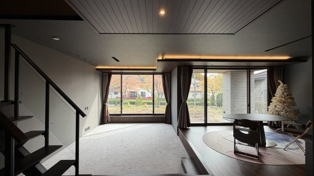 紫山5丁目　中古土建の居間・リビング|玄関からリビングダイニングにはいると、天井まで伸びる大きなサッシの向こうには、木々と街並みのコントラストが美しい。