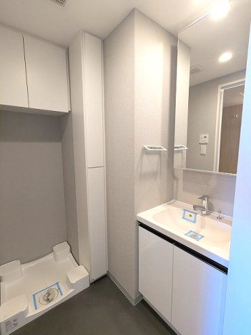 PROUD FLAT浅草の洗面所|トイレと独立した脱衣洗面室に洗濯機置場あります、洗濯機置場は排水口のお手入れしやすく手前中央に配置し、足高の防水パンです