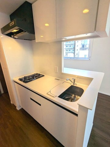 PROUD FLAT浅草のキッチン|ガス2口システムカウンターキッチン、瀟洒でお手入れ楽なガラストップコンロ、料理しやすいシンクカバー付です