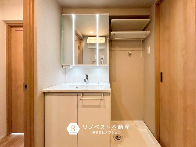 ハイム鴻池の独立洗面台|鏡にライトがついていて明るく身だしなみチェックにも役立ちますね！洗濯パンの上部にはラックがあるので洗剤などのストックを保管するのに便利です！