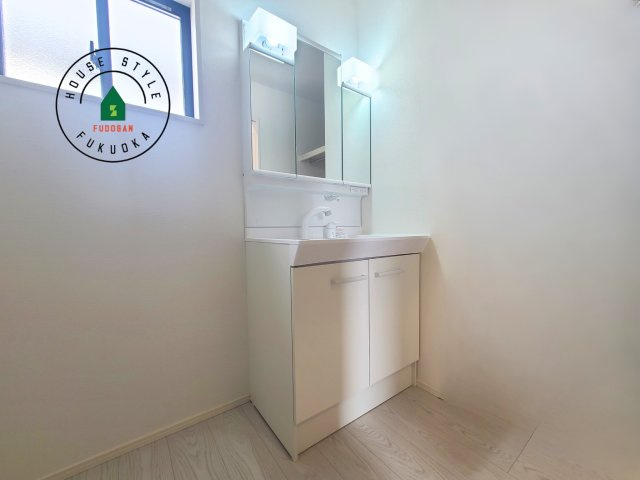 福岡市東区大岳2丁目第1-2棟（2号棟）の内観：施工例|毎日使うものだから清潔な空間を保ちたい水回り。洗面にはそんな願いを解消させてくれる収納アイデアが満載です。三面鏡の裏側にはキャビネットが現れ小物から背の高い物まで収納できます。