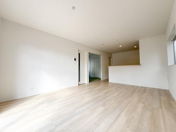 徳島第7-1号棟の居間・リビング|リビングは明るい色合いのフローリングが広がり開放的な雰囲気です。シンプルな内装でさまざまなインテリアに合わせやすいです。カウンターキッチンとの一体感があり快適な空間です。