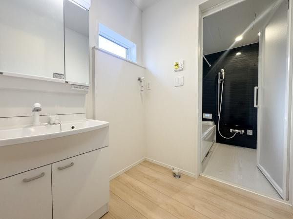 徳島第7-1号棟の独立洗面台|明るい洗面台・洗面所で清潔感があふれる空間です。収納スペースも充実しており使い勝手に配慮されています。廊下まで続く床のおかげで空間がより広々と感じられます。浴室との動線もスムーズです。