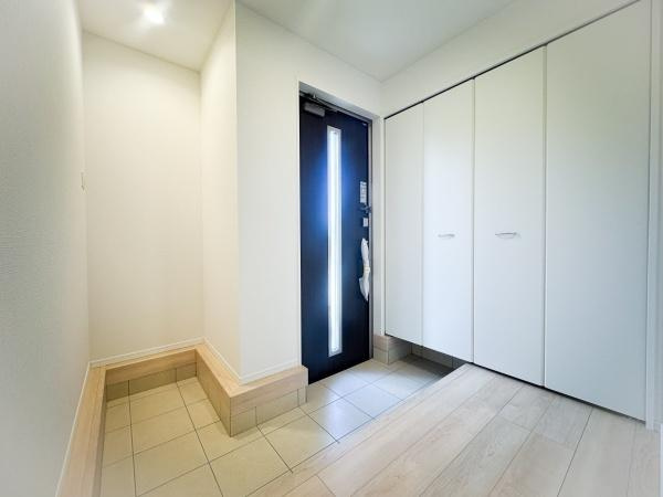 畑中第1-2号棟の洋室|明るい雰囲気の洋室です。天井まで続く収納スペースがありすっきりとした空間を保てます。白を基調とした内装が清潔感を演出しています。床材と玄関のコントラストが特徴的です。