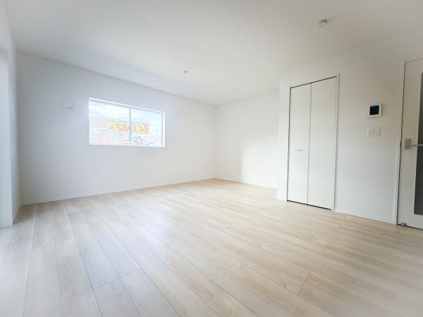 畑中第1-2号棟の居間・リビング|明るい色合いのフローリングが空間を広く見せてくれます。大きな窓から光が差し込むためリビングがより開放的な印象です。収納スペースもしっかり用意されているのですっきりと片付けやすいリビングです。