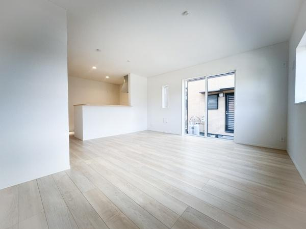 畑中第1-2号棟の居間・リビング|大きな窓から光が差し込む明るいリビングです。開放感のある空間で過ごしやすい雰囲気が広がります。淡い色合いの床材が清潔感を引き立てます。キッチンとのつながりもスムーズな設計です。