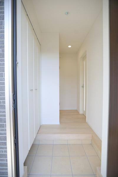 横田第2-2号棟の玄関|明るい雰囲気の玄関が印象的です。シンプルなデザインで清潔感があります。収納スペースが豊富で使いやすさが感じられます。段差も緩やかで安心です。