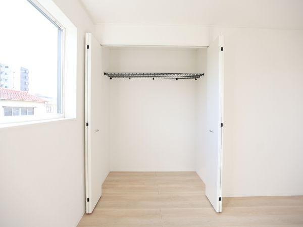 横田第2-2号棟の収納|白を基調とした収納スペースで明るい印象が特徴的です。クローゼット内のハンガーパイプも設置済みで使いやすさが感じられます。扉を開けてもすっきりとした空間が広がります。