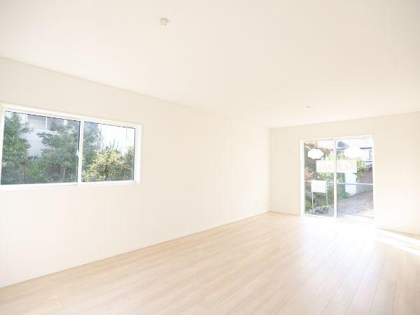 横田第2-2号棟の居間・リビング|大きな窓から光が差し込む開放的なリビングです。ナチュラルなフローリングが明るさを引き立てます。室内は白を基調としたシンプルな空間になっています。外とつながる窓から季節の移ろいも感じられます。