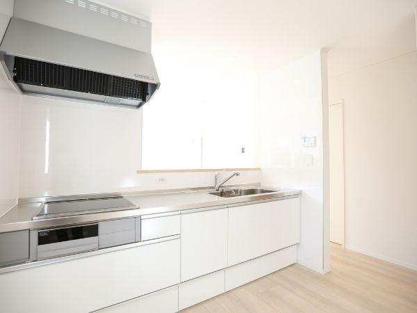 横田第2-2号棟のキッチン|白を基調としたキッチンは空間を明るく見せてくれます。シンプルなデザインでまとめられており掃除もしやすそうです。収納も豊富に備わっているので整理整頓がしやすい印象です。