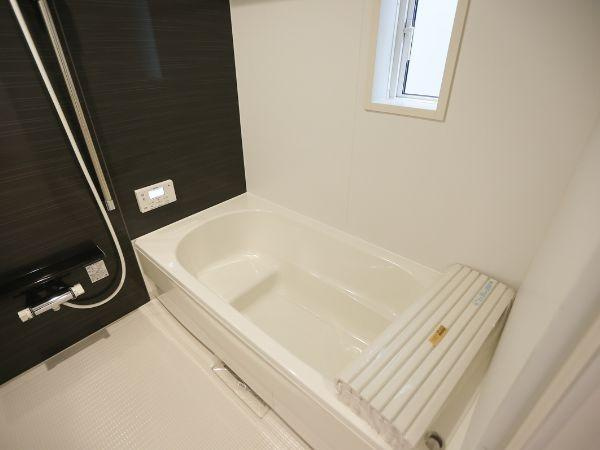 横田第2-2号棟の浴室|シンプルなデザインが特徴のバスルームです。明るい空間で快適にご利用いただけます。小窓があり換気もしやすい仕様です。追い焚き機能対応のフタも付属しています。清潔感のある浴槽が魅力です。