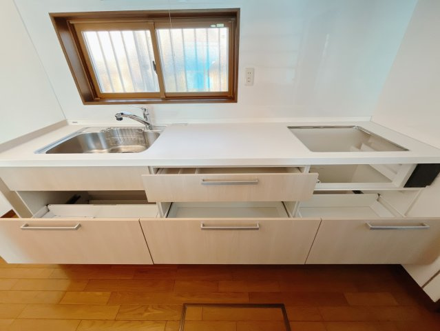 【中古戸建】伊勢崎市西久保町1丁目のキッチン|■キッチン｜ワークトップ下には、圧力鍋やパスタ鍋などのかさばる調理器具もラクラク収納可能なスライド収納！ものが溢れがちなキッチン回りもスッキリきれいに管理ができます♪