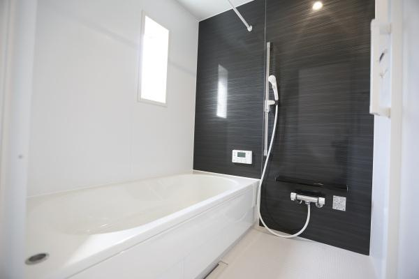 徳島第6-1号棟の浴室|シンプルで清潔感のある浴室は毎日の使いやすさを重視したデザインです。小窓から自然光が入るため明るさが感じられます。黒を基調としたパネルが空間を引き締めすっきりとした印象です。