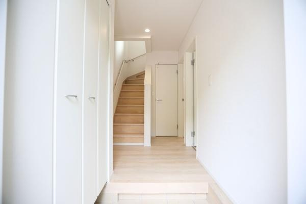 徳島第6-1号棟の玄関|玄関はシンプルで清潔感のある空間です。床と建具の色合いが調和しています。収納スペースも確保されています。照明が明るく玄関全体がすっきりとした印象です。