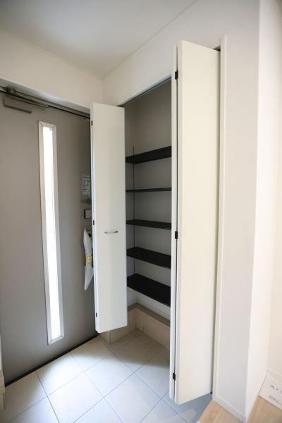 徳島第6-1号棟の玄関|玄関に設けられた収納スペースが便利です。シンプルな棚設計で多目的に使えます。すっきりとした印象の玄関で整理整頓がしやすくなっています。両開き扉で物の出し入れもスムーズに行えます。