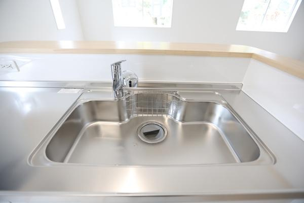 徳島第6-1号棟の独立洗面台|鏡裏や足元に豊富な収納スペースが備わった洗面台です。落ち着いた色合いの内装が特徴的です。明るい窓からの自然光が室内を照らします。シンプルなデザインもポイントです。