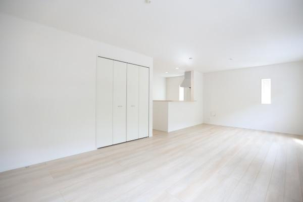 徳島第6-1号棟の居間・リビング|リビングは明るい色合いのフローリングが広がり窓から自然光がしっかりと入ります。収納スペースも備わっておりすっきりとした空間が特徴です。キッチンまでの動線もスムーズなレイアウトです。