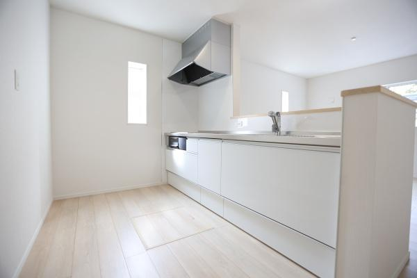 徳島第6-1号棟のキッチン|明るい印象のキッチンはシンプルなデザインでお手入れがしやすいです。広い調理台が確保されているため作業もゆったり行えます。収納も豊富で整理整頓がしやすい仕様です。