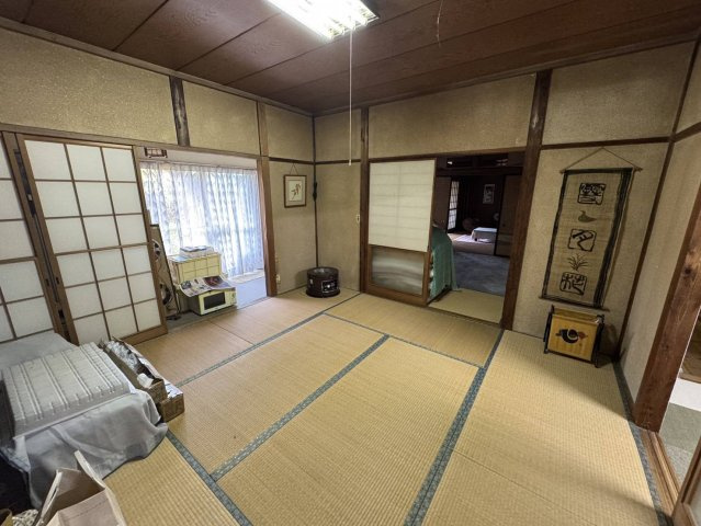 壮大な土地にそびえたつ平屋、大型車庫、作業場ものその他共用部分