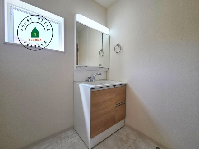 粕屋郡篠栗町田中4丁目第3-1棟（1号棟）の内観：施工例|毎日使うものだから清潔な空間を保ちたい水回り。洗面にはそんな願いを解消させてくれる収納アイデアが満載です。三面鏡の裏側にはキャビネットが現れ小物から背の高い物まで収納できます。