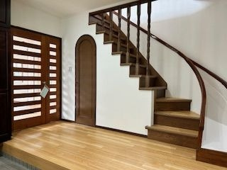 【玄関】 | 福岡市中央区小笹１丁目 戸建て | 広い玄関スペースはご家族が多いご家庭にもおすすめです。カーブのかかった階段がおしゃれ