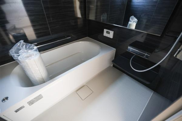 AG-HOUSE　ゆめが丘　B棟の浴室|落ち着いた色合いの壁面と清潔感のある浴槽が印象的です。浴室乾燥機や大きめの鏡も備わっています。奥行きのあるバスタブでゆったりとしたスペースが確保されています。