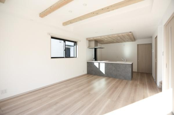 AG-HOUSE　ゆめが丘　B棟の居間・リビング|明るい光が差し込むリビングはナチュラルな木目調の床と天井の梁がアクセントです。開放感のある空間でキッチンとの一体感が魅力となっています。窓からの自然光が印象的で室内全体に清潔感があります。