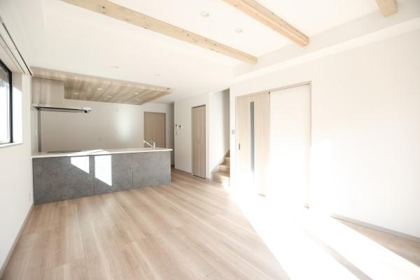 AG-HOUSE　ゆめが丘　B棟の居間・リビング|リビングは明るい陽射しが差し込む空間です。木目調の床と天井のアクセントが調和しています。キッチンとの一体感も感じられます。開放感のあるレイアウトが魅力で、シンプルで落ち着きのあるデザインです。