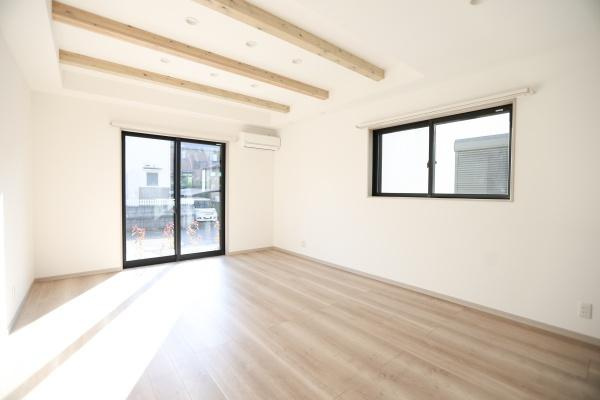AG-HOUSE　ゆめが丘　B棟の居間・リビング|リビングには大きな窓があり自然光がたっぷり差し込みます。天井の梁がアクセントとなりシンプルな中にも個性を感じます。壁や床の色合いが明るく開放的な空間です。